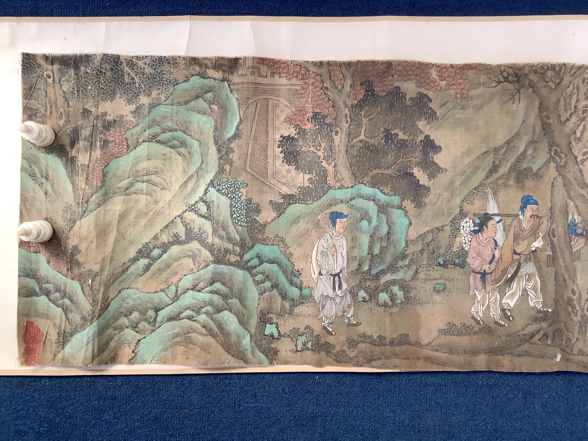 A 19th century Chinese hand scroll painting on silk of figures in a landscape, approximately 206 cm X 32.5 cm